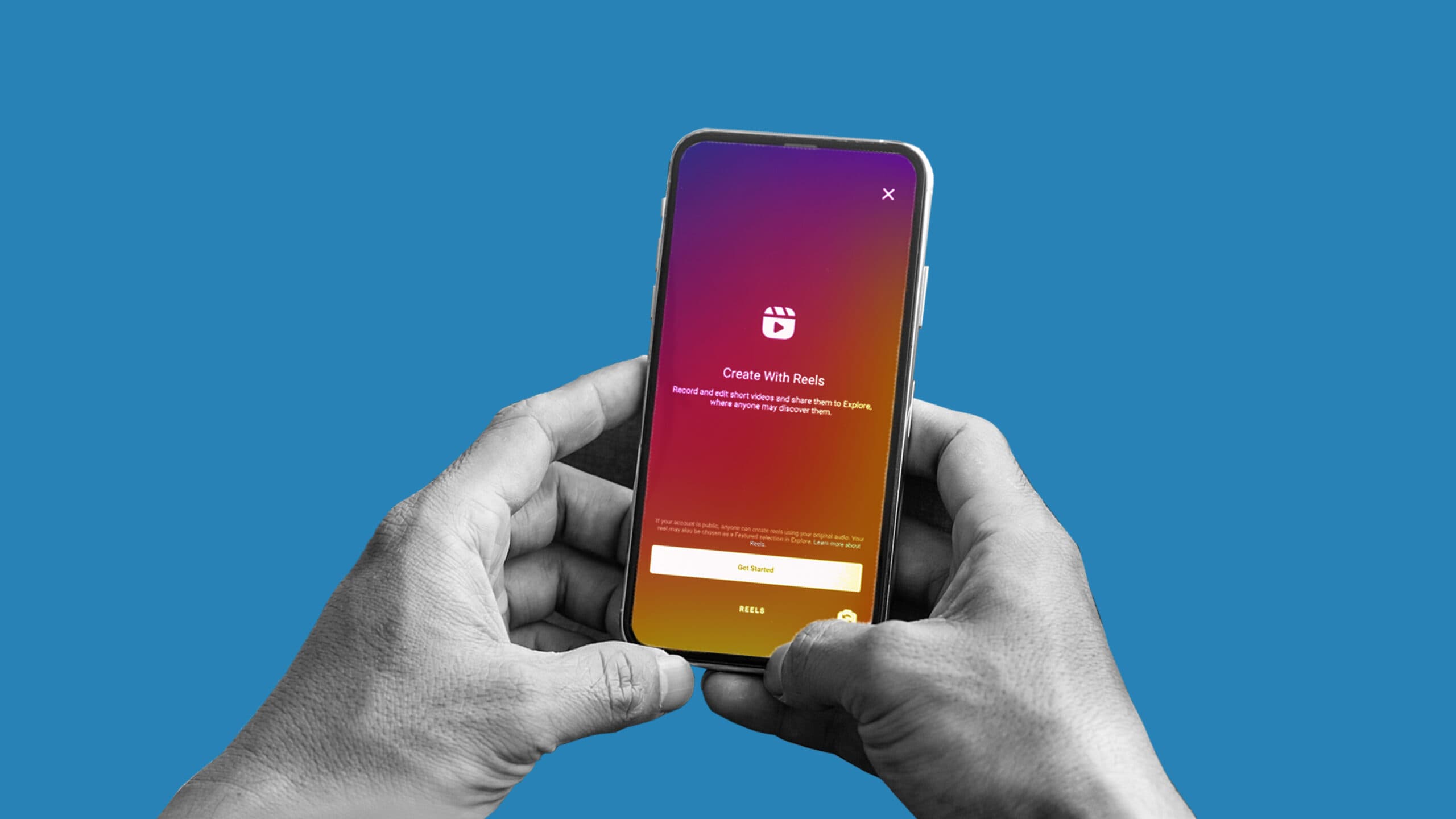 This image has a blue background and features two hands holding a smart phone. On the phone, you can see the someone starting to create a Reel on Instagram. This image represents Instagram Reels.
