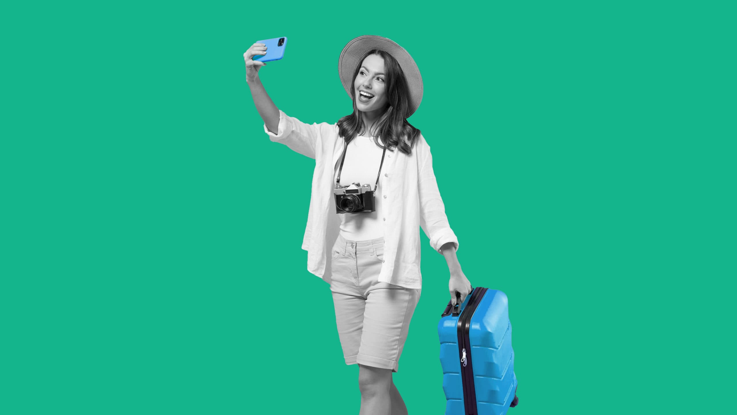 This image features a person in vacation attire, with a camera around their neck, taking a selfie with their cell phone. They are also carrying a carryon suitcase.